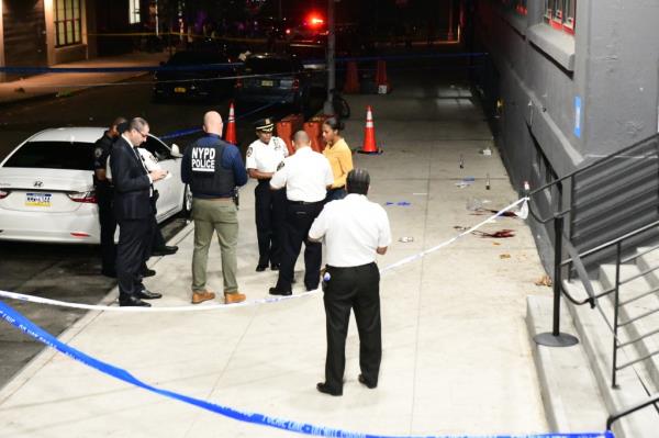 NYPD cops investigate a multiple shooting outside a Brooklyn migrant shelter.