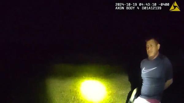 Bodycam footage shows suspect in handcuffs.