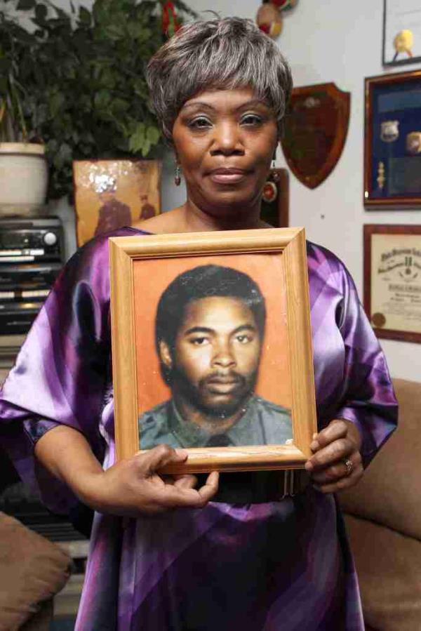 A woman holds a picture of a man.
