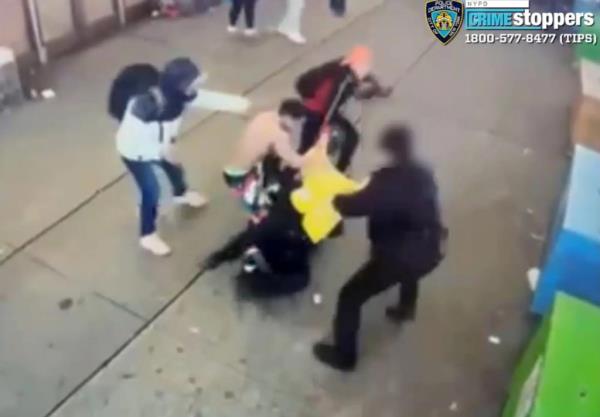 Grainy surveillance footage of several men beating on two police officers.