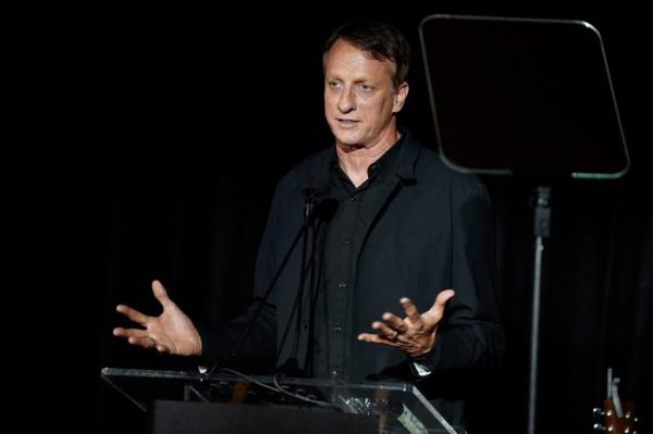 Skateboarding legend Tony Hawk speaking at a podium.