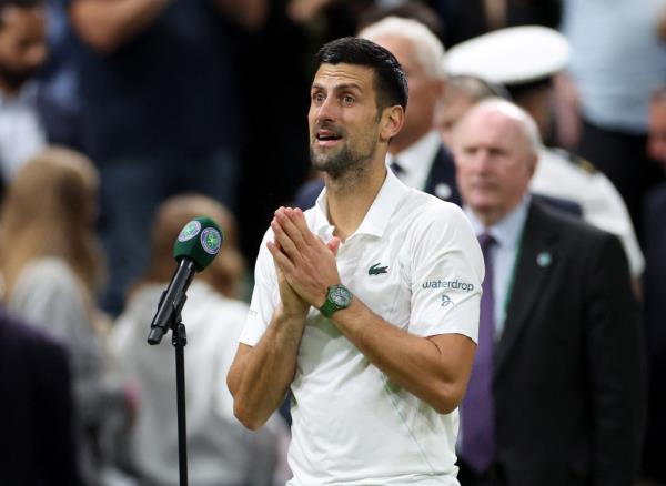Novak Djokovic in a white shirt, scolding the crowd after winning his fourth round match at Wimbledon 2024