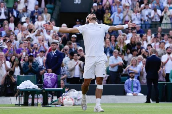 Lorenzo Musetti of Italy celebrating his victory over Taylor Fritz of the United States in the quarterfinal match at Wimbledon 2024 with arms outstretched