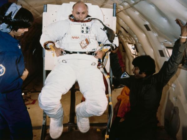 Mattingly II, Commander of the STS-4 NASA Space Shuttle mission on the shuttle Columbia, learns to put on and take off his spacesuit on board a Boeing KC-135 Stratotanker zero-gravity simulator aircraft (known as the 'Vomit Comet'), 22nd July 1981.