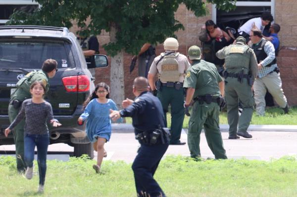 Children run to safety after escaping from a window during a mass shooting at Robb Elementary School.
