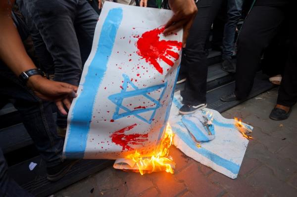 Demo<em></em>nstrators burn banners depicting the Israeli flag during a protest against Israel and the USA in support of Palestinians for those killed in a blast at Al-Ahli hospital in Gaza that Israeli and Palestinian officials blamed on each other, amid the o<em></em>ngoing co<em></em>nflict between Israel and Hamas, in Cairo, Egypt, October 18, 2023
