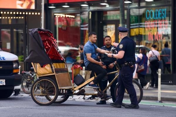A pedicab driver getting stopped by NYPD in Midtown on July 2, 2024.