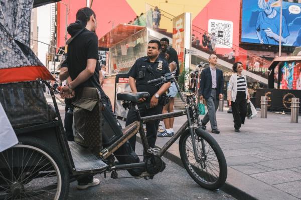 A pedicab driver getting detained by the NYPD in Times Square.