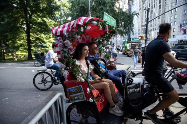 A pedicab driver taking a man and woman for a ride in Central Park, New York City