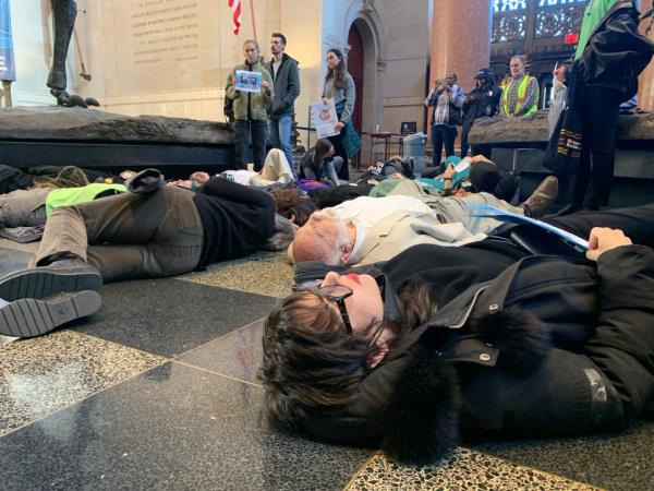 Climate protesters are seen lying on the ground of the Museum of Natural History during the 