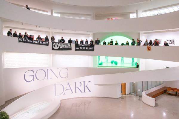 Protesters are seen hanging signs from the bannisters at the Guggenheim.