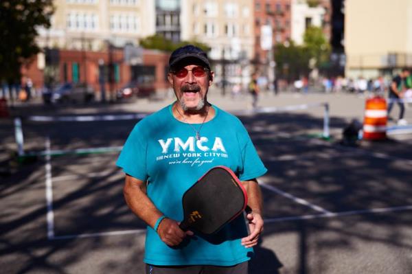 Angel Ramirez with pickleball paddle on picklball court. 