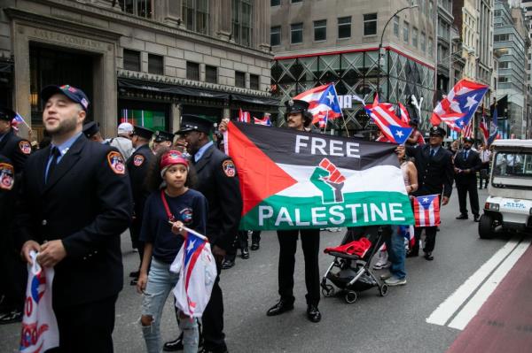 A member of the FDNY hold up a flag reading 