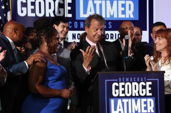 Westchester County Executive George Latimer speaking at a podium to supporters after winning his race in the 16th Co<em></em>ngressional District of New York's Democratic primary