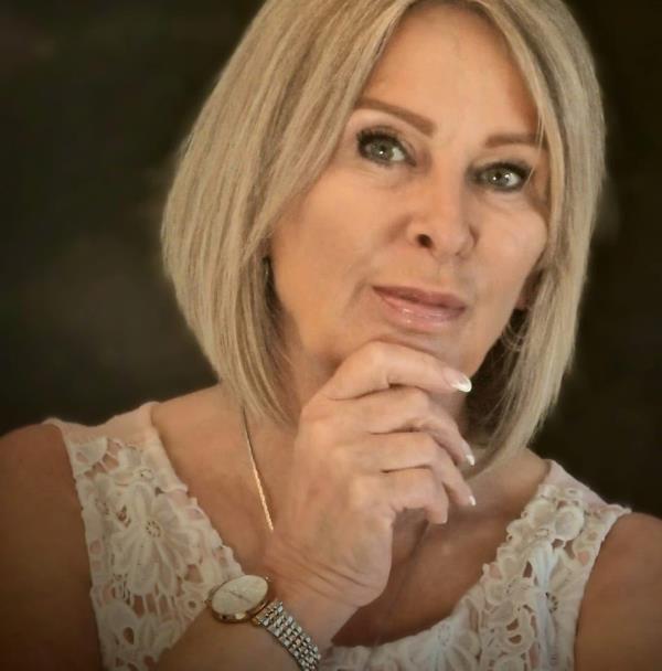 A photo of Julie Cobley holding her hand to her chin.