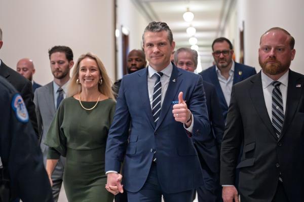 Pete Hegseth and his wife Jennifer Rauchet walking towards the Capitol, with Hegseth giving a thumbs-up, for a meeting with Sen. Joni Ernst