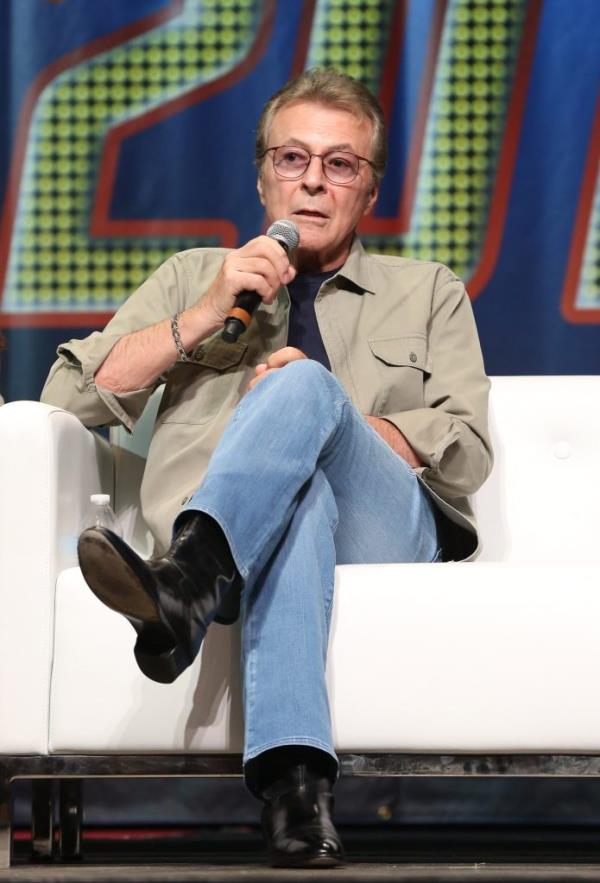 Actor James Darren sitting on a white couch, holding a microphone at the Star Trek Las Vegas Convention