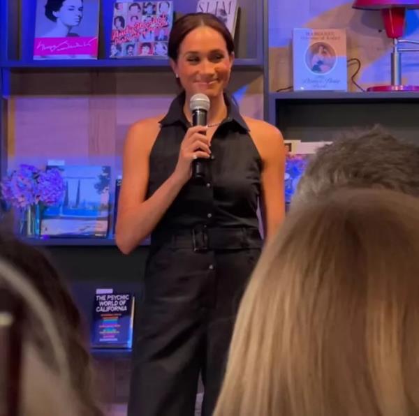 Meghan Markle, Duchess of Sussex, making a surprise appearance and holding a microphone at a bookstore opening in Santa Barbara, California.
