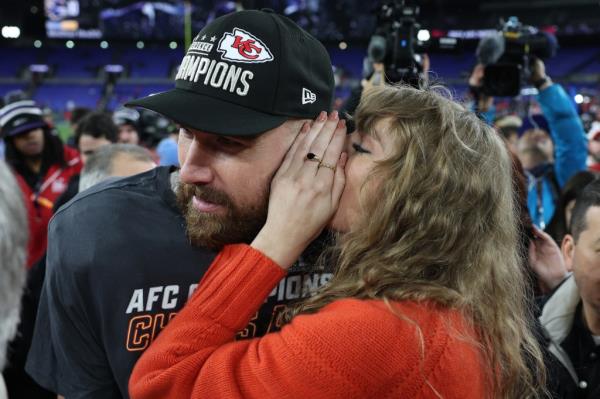 Taylor Swift whispers into Travis Kelce's ear.