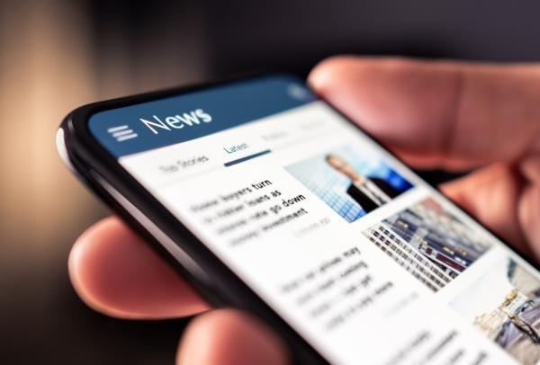 News o<em></em>nline in phone. Reading newspaper from website.