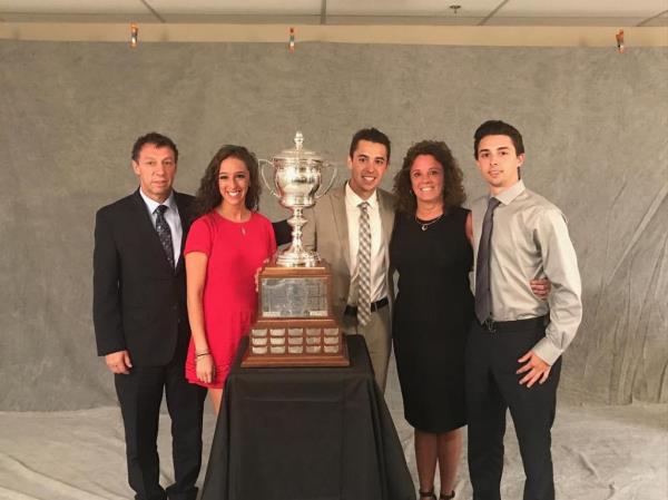 Brothers Johnny and Matthew Gaudreau posing with their family and a trophy