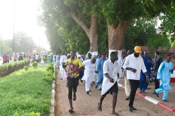 Demo<em></em>nstrators flee after warning shots were fired while they protest Bazoum's detention.