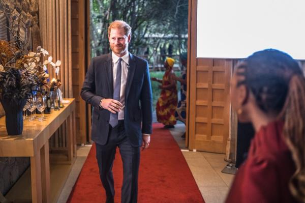 Prince Harry, Duke of Sussex, attending a Sentebale reception and panel discussion in a suit, walking down a red carpet at The Saxon Hotel in Johannesburg, South Africa.