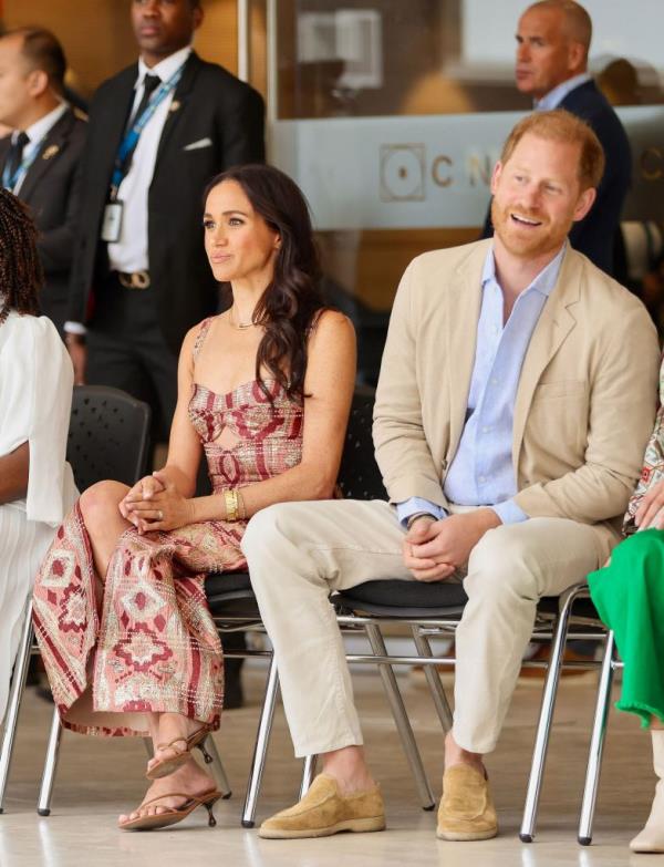 Prince Harry and Meghan Markle sitting with a group of people during their visit to Colombia