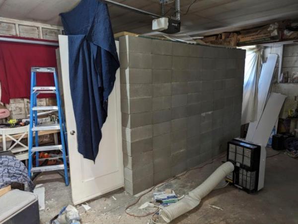 This undated photo provided by the Federal Bureau of Investigation's Portland Field Office shows a makeshift cinderblock cell in Klamath Falls, Ore. allegedly used by 29-year-old, Negasi Zuberi. A federal judge has set an Oct. 17 trial date for the Oregon man accused of posing as an undercover police officer, kidnapping a woman in Seattle and locking her in the cell until she bloodied her hands breaking the door to escape. Zuberi made his initial appearance in federal court in Medford on Monday, Aug. 14 before U.S. Magistrate Judge Mark D. Clarke. (FBI via AP)