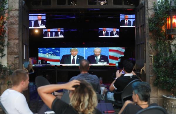 People sit and watch a broadcast of the first debate between President Do<em></em>nald Trump and Democratic presidential nominee Joe Biden with socially distanced outdoor seating at The Abbey on September 29, 2020 in West Hollywood, California.