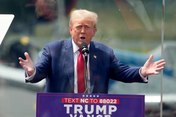 Former US President and Republican presidential candidate Do<em></em>nald Trump speaks behind bulletproof glass during a campaign rally at the North Carolina Aviation Museum & Hall of Fame in Asheboro, North Carolina, August 21, 2024. 