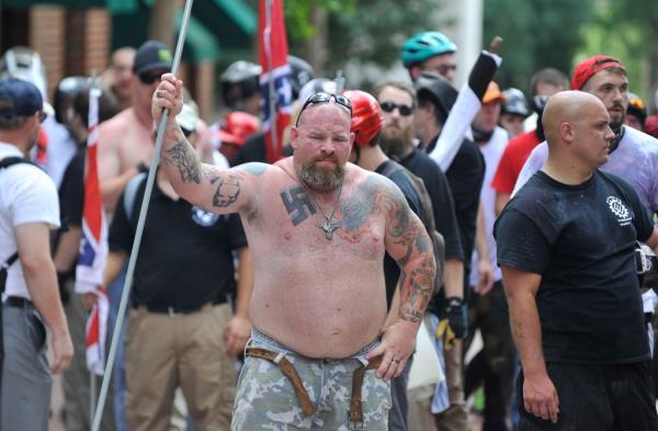 A white supremacist man holding a long pipe at a rally in Charlottesville, Virginia during a state of emergency