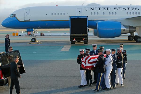 pictured are military members carrying Feinstein's coffin off a plane. 
