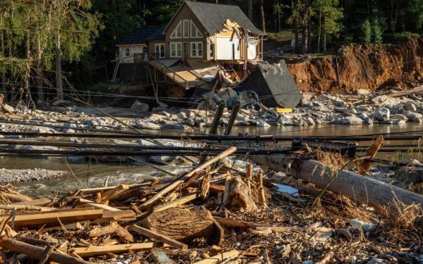 Storm damage and destruction in downtown Chimney Rock, North Carolina with a destroyed house by a river, photographed on October 5, 2024.