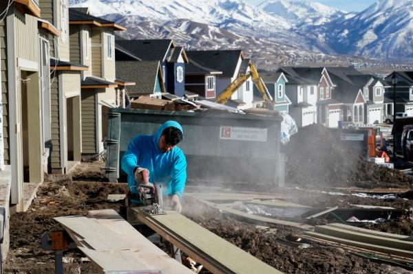 A worker prepares siding to install on a single family home under co<em></em>nstruction in Lehi, Utah
