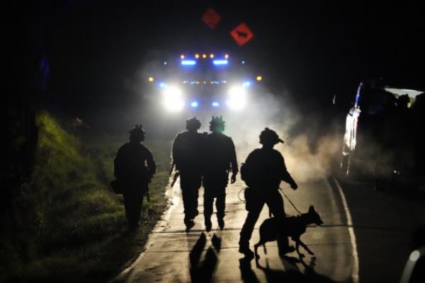 A Maryland TAC team walk out out of a field after law enforcement surrounded a property in Bowdoin, Maine, believed to be co<em></em>nnected to Lewiston shooting suspect Robert Card.