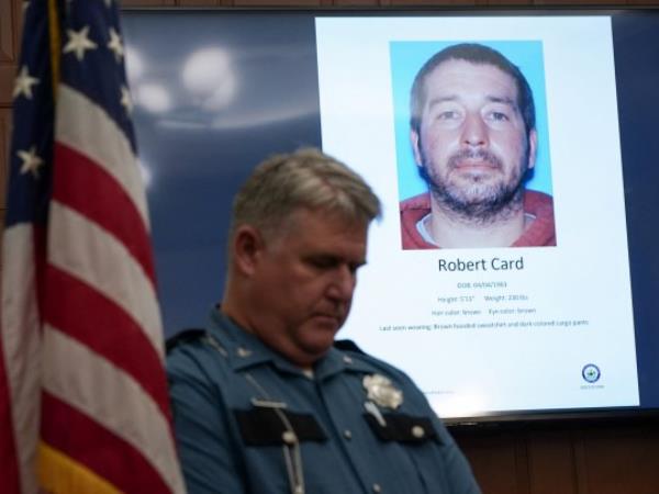A police officer stands next to a screen displaying the picture of the suspected shooter, during a press co<em></em>nference following the deadly mass shooting, at City Hall in Lewiston, Maine, U.S. October 27, 2023. REUTERS/Kevin Lamarque