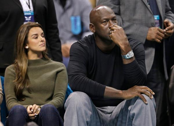 Michael Jordan, right, watches the action with his wife, Yvette Prieto, left, in the first half of an NBA basketball game between the Charlotte Hornets and the Atlanta Hawks