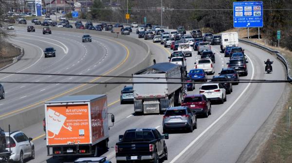 A motorcycle cruises down the breakdown lane as solar eclipse seekers and drivers head north on Route 93 