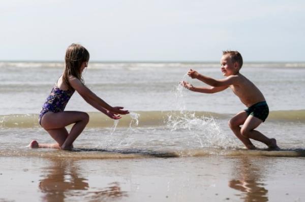 Diana (7) and Max (4) Danylyshyn splash in the sea at Camber Sands in East Sussex. Picture date: Thursday August 10, 2023. PA Photo. Photo credit should read: Jordan Pettitt/PA Wire