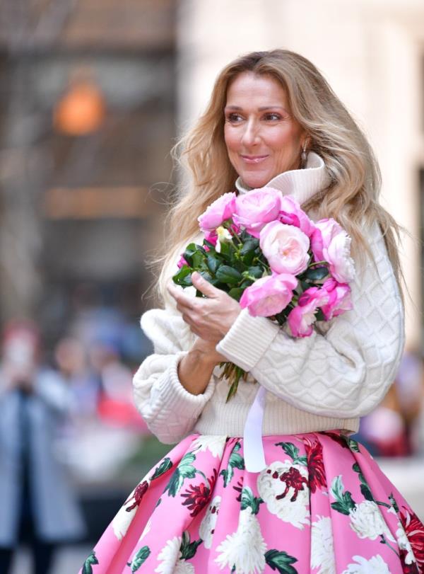 Celine Dion smiling wearing pink. 