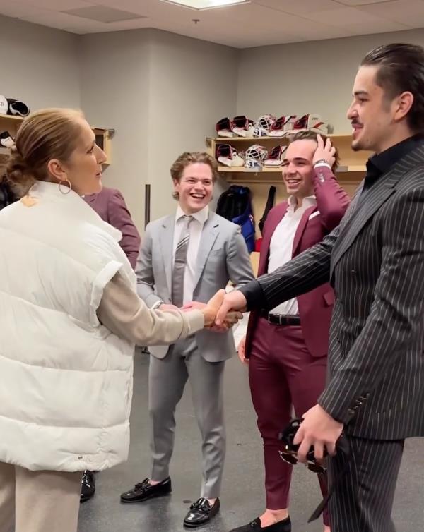 Celine Dion shaking hands with hockey players. 