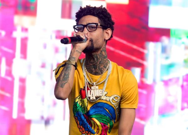 Philadelphia rapper PnB Rock performing at the 2018 Firefly Music Festival in Dover, singing into a microphone