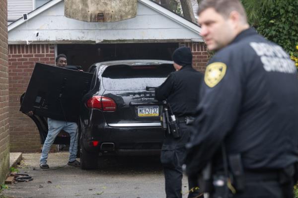 Denton Gayle carries out a large screen television while sheriff's deputies look on.