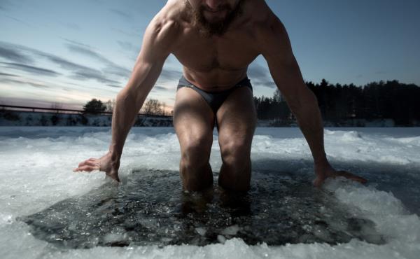 Young man havin<em></em>g recreatio<em></em>nal swim in the ice hole