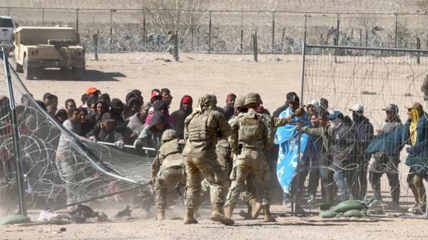 Migrants push through Texas border wire in El Paso