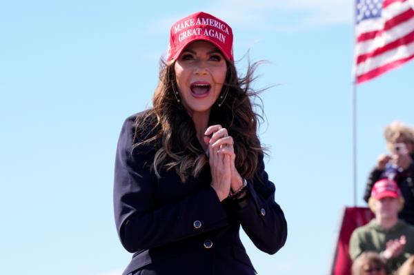 Noem wears a red Make America Great Again cap and gasps with glee