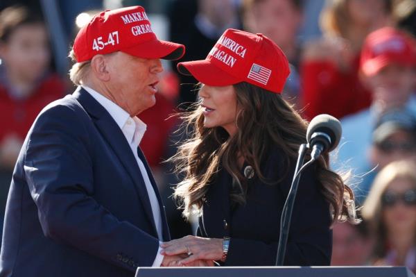 Do<em></em>nald Trump and noem can be seen greeting each other on stage at a rally
