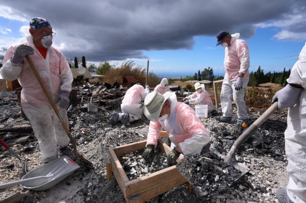 Members of Samaritan's Purse, a humanitarian aid organization, sift through the rubble of a home destroyed by the Kula wildfire as they search for a wedding ring belo<em></em>nging to the homeowner on Friday, August 25, 2023 in Kula, Hawaii.  
