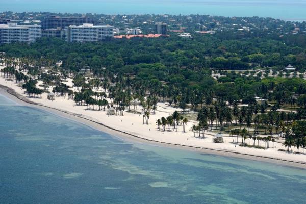 Aerial view of an empty Crandon Park in Key Biscayne, Florida during Coro<em></em>navirus shutdown with beach, trees and buildings visible